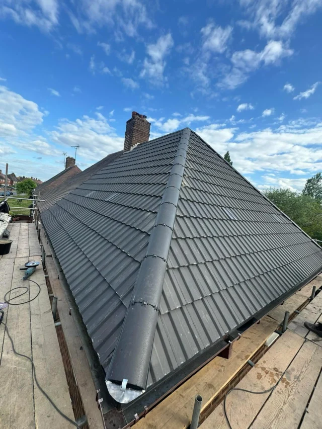 Newly completed dark grey tiled hipped roof on a Staffordshire home
